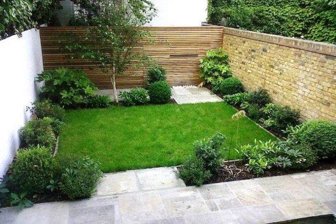 green-grass-small-bushes-trees-hedges-small-backyard-landscaping-cement-tiles-brick-wall-690x460